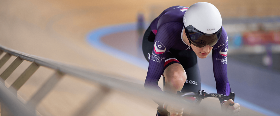 Charlie racing in purple Loughborough University cycling kit wearing a white helmet at a track velodrome race