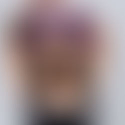 A woman stands poised on a sunlit train platform, ready for her journey with a stylish carry-on suitcase