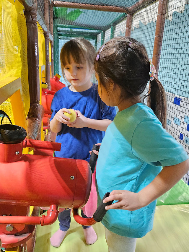 Two preschool girls talking to each other at a playground