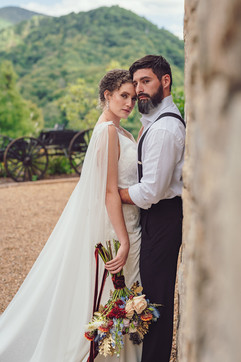 bride and groom posing with colorful fall bouquet