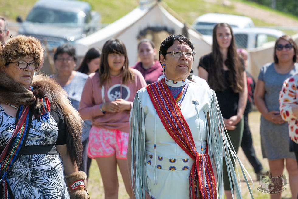 A candid outdoor photograph from an Elders gathering in Pinehouse Lake, Saskatchewan. In t
