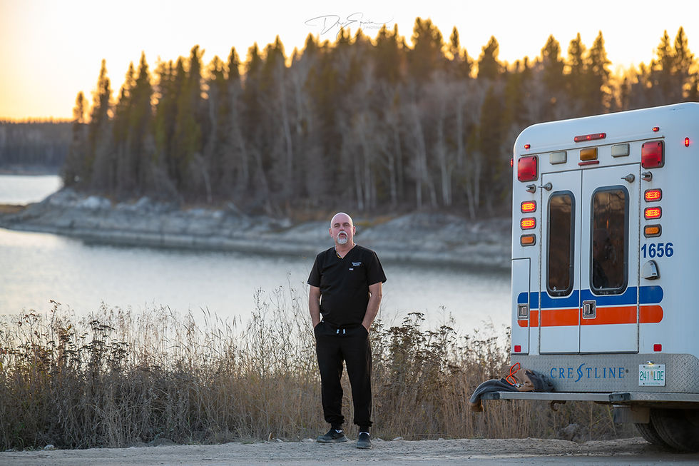Todd Brown, a Registered Nurse with Additional Authorized Practice (RN-AAP), standing next to an emergency vehicle in Sandy Bay, Saskatchewan. Photo by Dre Erwin.