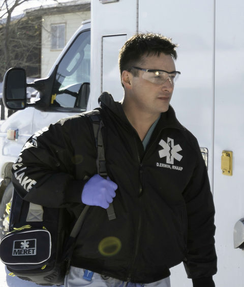 Dre Erwin, RN, in scrubs walks beside an ambulance in the snowy northern Saskatchewan landscape.