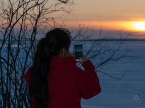 Someone taking photos of a sunset in winter