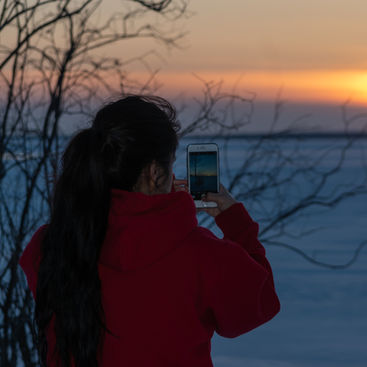 Someone taking photos of a sunset in winter