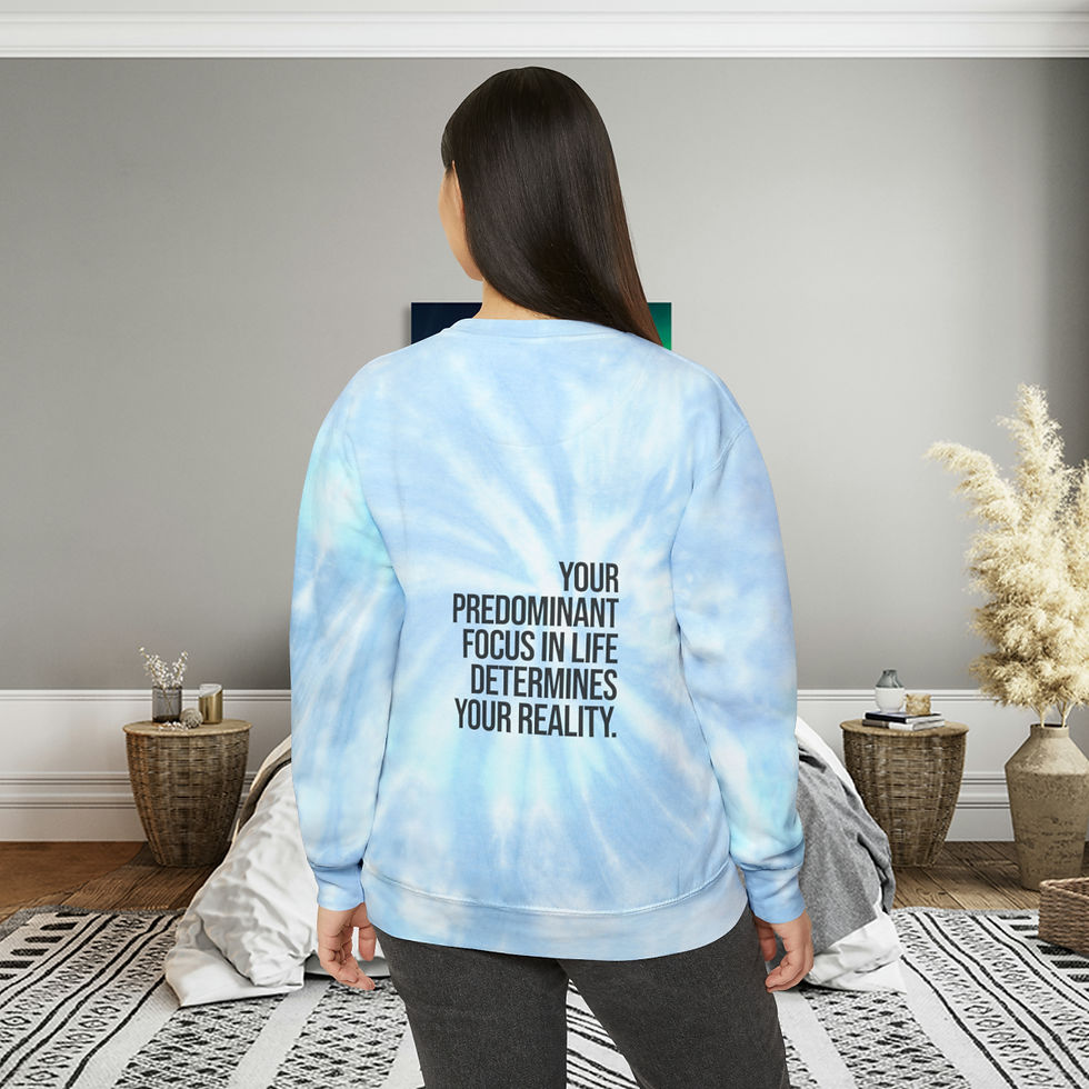 Miniature : An image features a lady wearing a vibrant tie-dyed sweater designed by Dre Erwin. The sweater displays an inspiring message: 'Your predominant focus in life determines your reality.' The colorful, artistic design of the sweater complements the empowering message, creating a visually striking and motivational garment