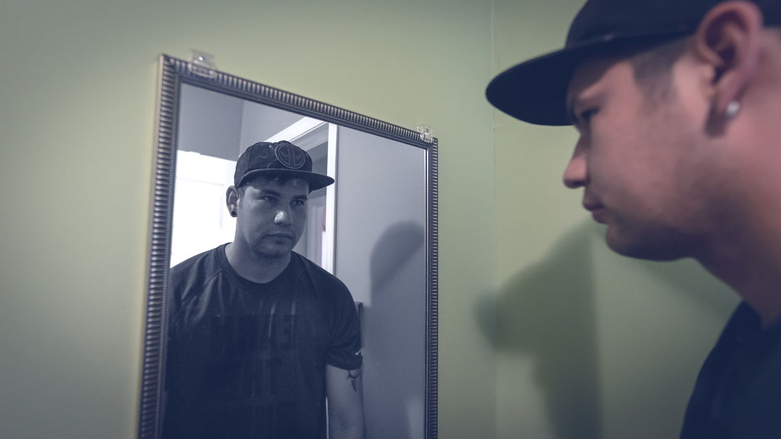 Man reflecting in mirror, portraying introspection and self-reflection.