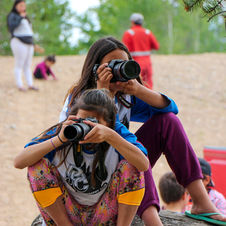 Therapeutic photography project showing Indigenous youth photographing Elders, representing cultural preservation and intergenerational connection in Pinehouse, Saskatchewan.