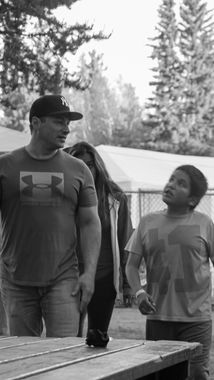 Dre Erwin, RN, mentors a youth in photography at the Pinehouse Lake Elders Gathering.