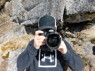 Dre Erwin holding a camera in front of his face, ready to capture moments.