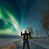 Man in front of the northern lights, in Pinehouse Lake