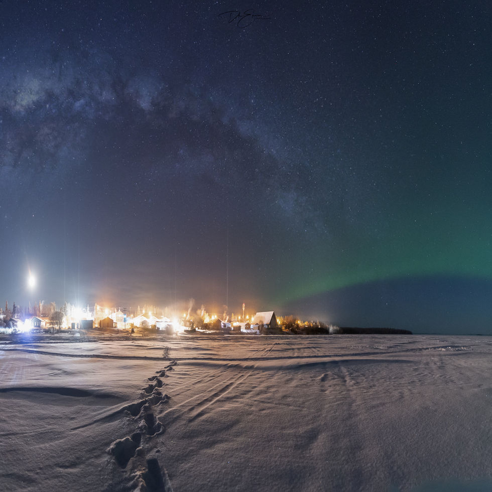 An awe-inspiring night sky over Pinehouse, urora Borealis in the cold of wintSaskatchewan, revealing the Milky Way and the ethereal dance of the Aer