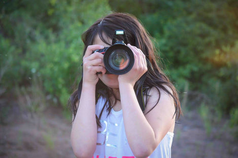Un jeune homme derrière un appareil photo, capturant la beauté thérapeutique du lac Pinehouse à travers la photographie.
