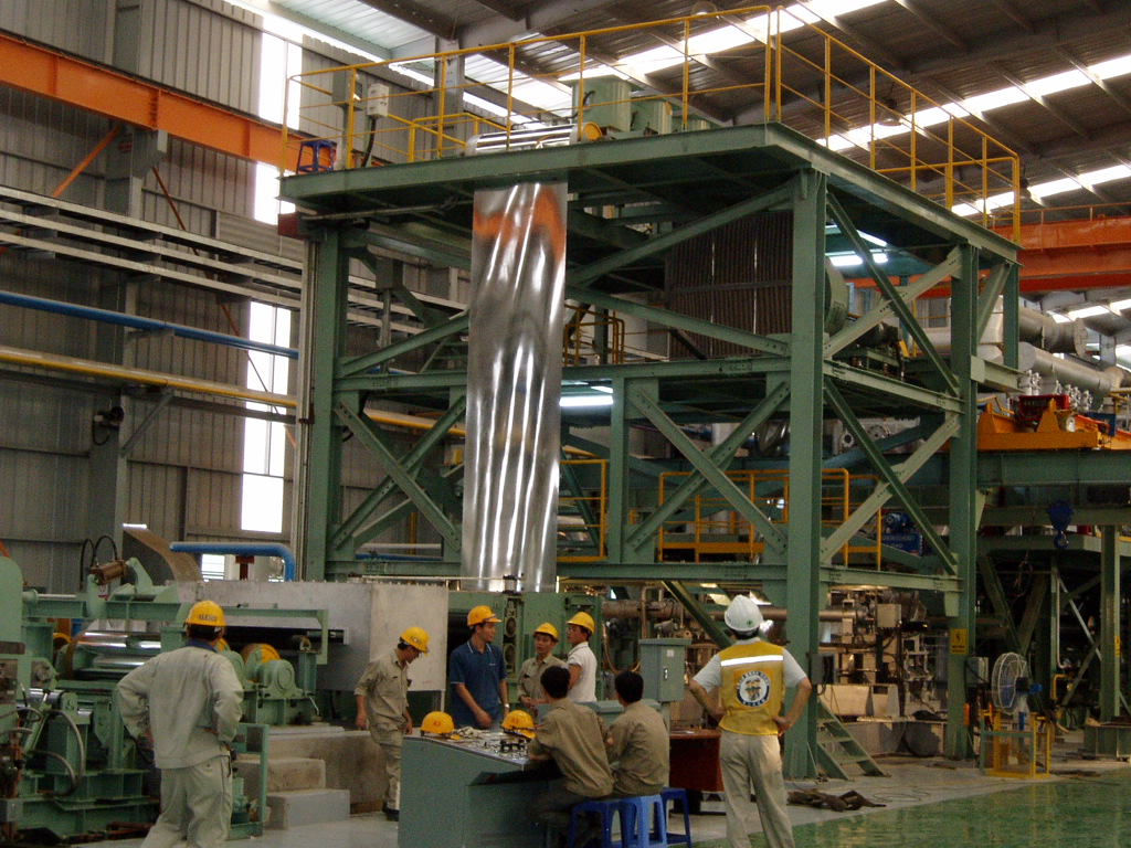 Large vertical looper with zinc-coated steel strip exiting the zinc pot in a Continuous Galvanizing Line (CGL). Enables smooth material flow and tension control during zinc alloy coating process. Engineered by DongHae MMC, Korea