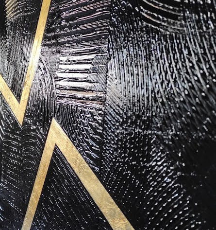 Lumière captée sur le tableau avec des reflets sur le noir brillant.