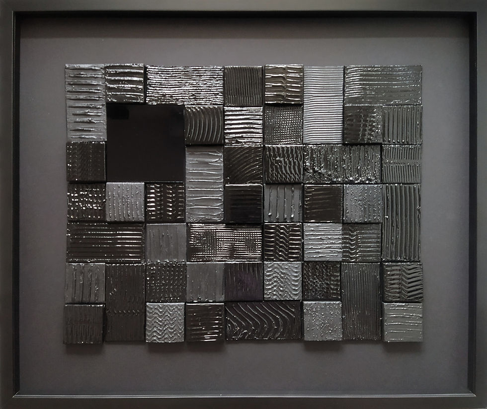 Tableau abstrait noir composé de prtites toiles enduites et noires reflétant la lumière.