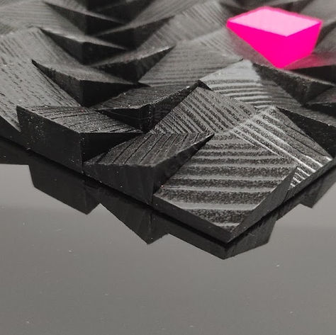 Vue plongeante des cubes noirs et du cube couleur fushia.