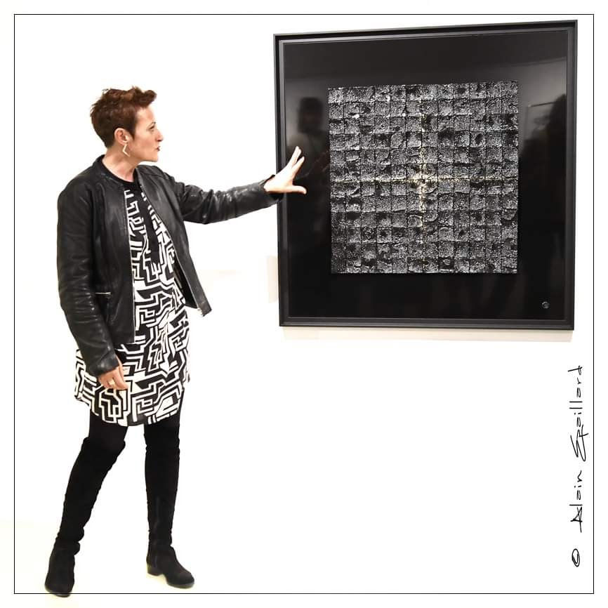 Veronique bauquel présentant son oeuvre lors d'un vernissage.