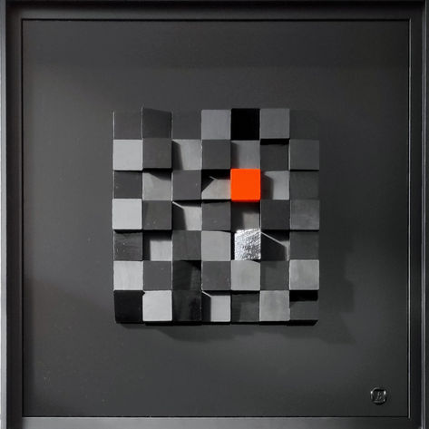 Composition de cubes en bois noirs et un seul cube orange sur un fond noir.