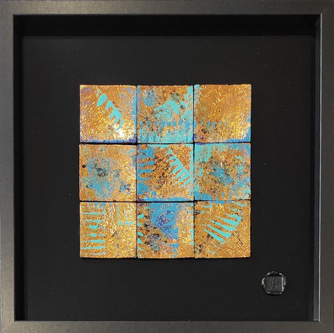 Oeuvre abstraite composée de carrés cuivrés, rehaussés de bleu,  reflétant la lumièr