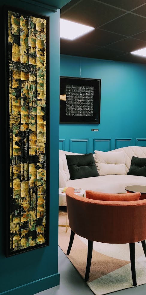 Tableau accroché à la verticale dans un intérieur aux couleurs contemporaines.