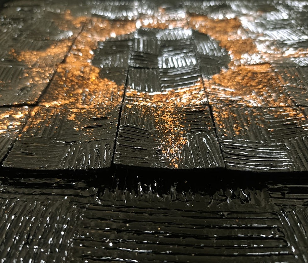 Reflection de la lumière sur les reliefs du support et des carrés noir brillant rehaussés de cuivre.