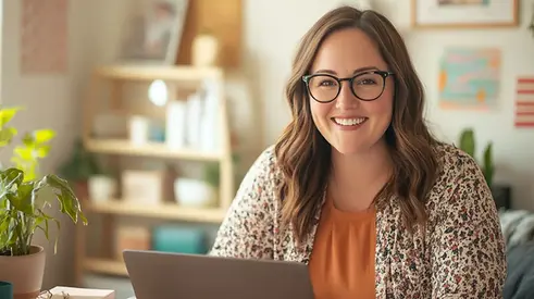 Smiling female teacher working from home on a laptop, representing the My Mindful Class Affiliate Program, a flexible side hustle opportunity for educators to earn income by promoting mindfulness-based SEL resources for K–12 classrooms.