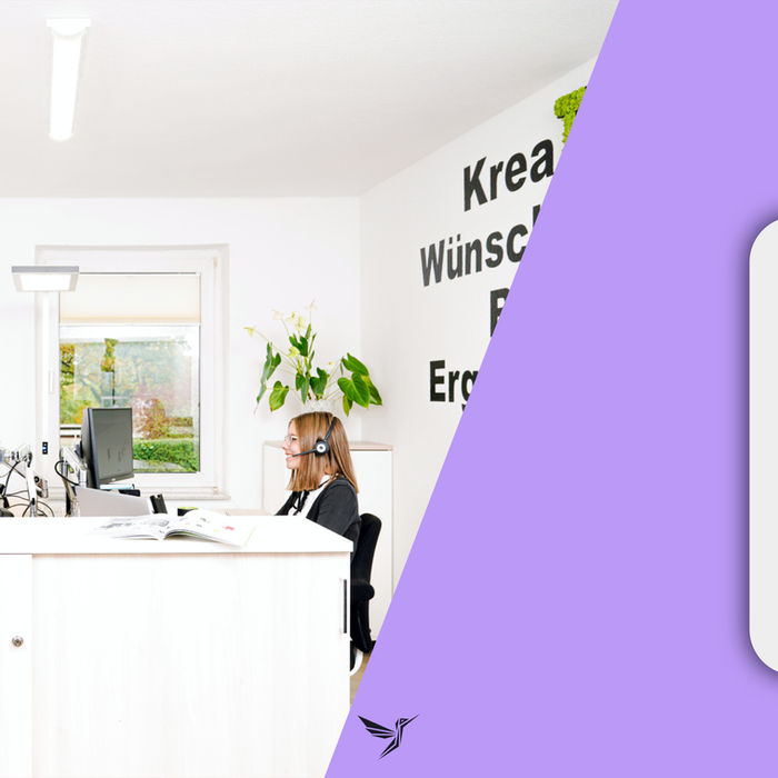 Eine Mitarbeiterin im modernen Büro mit Headset arbeitet am Computer; im Hintergrund ist eine motivierende Wandbeschriftung zu sehen.