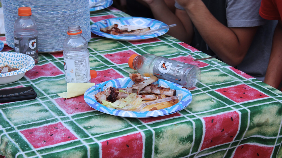 Paper plates with finished ribs around a crowded campground table