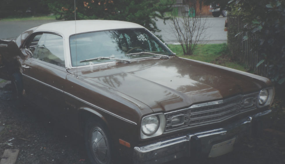 Photograph of a damaged brown Plymouth Duster parked beside a fence after a brake repair accident.