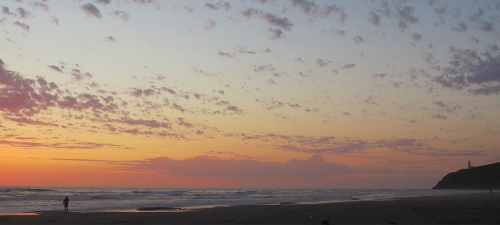 Sunset over the Pacific Ocean at Cape Disappointment State Park with North Head Lighthouse visible on the bluff.