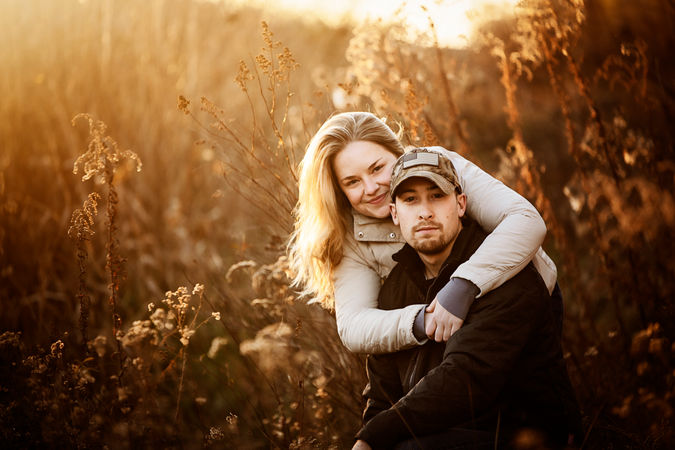 woman hugs man over his shoulders in vibrant field in New Hampshire