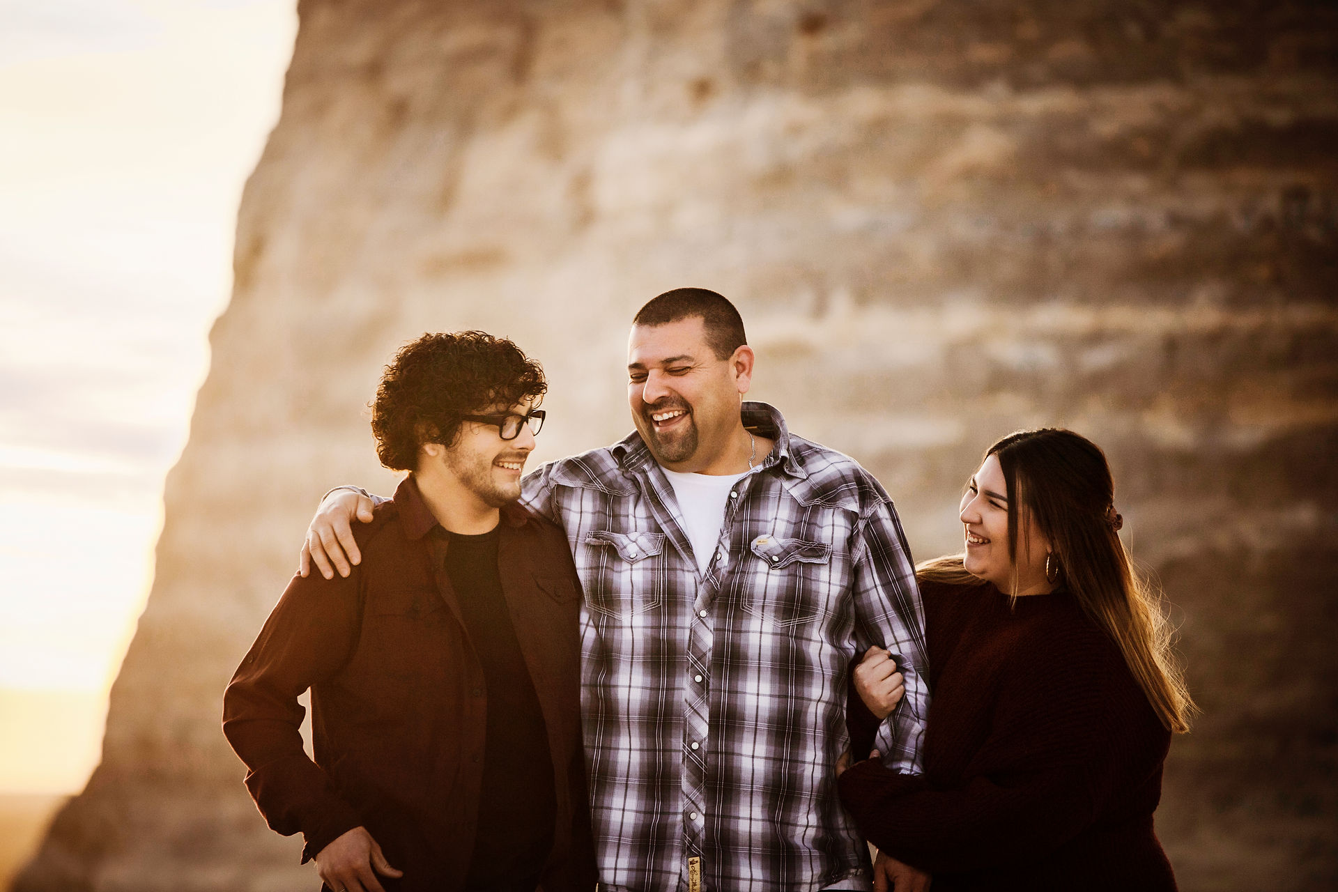 man in plaid laughs with his grown son and daughter at the monument rocks in kansas