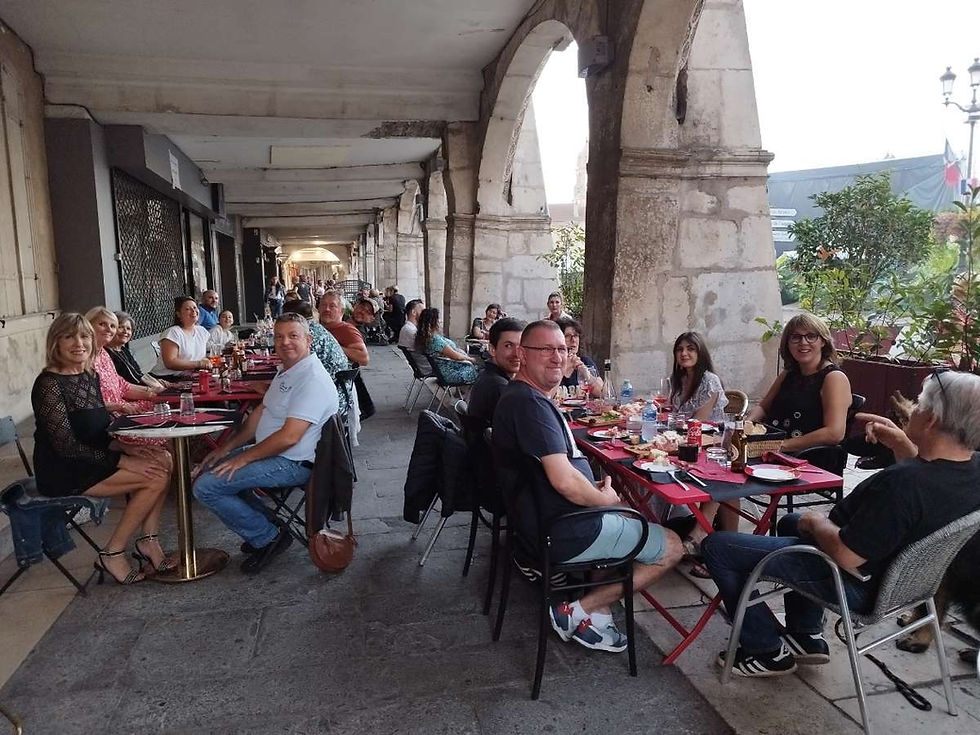 Clients en terrasse d'une épicerie fine italienne sous des arcades.