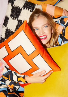 A photograph of a model buried under cushions