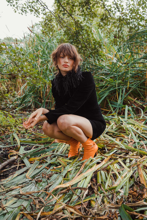 A photograph of a model posed close to the ground