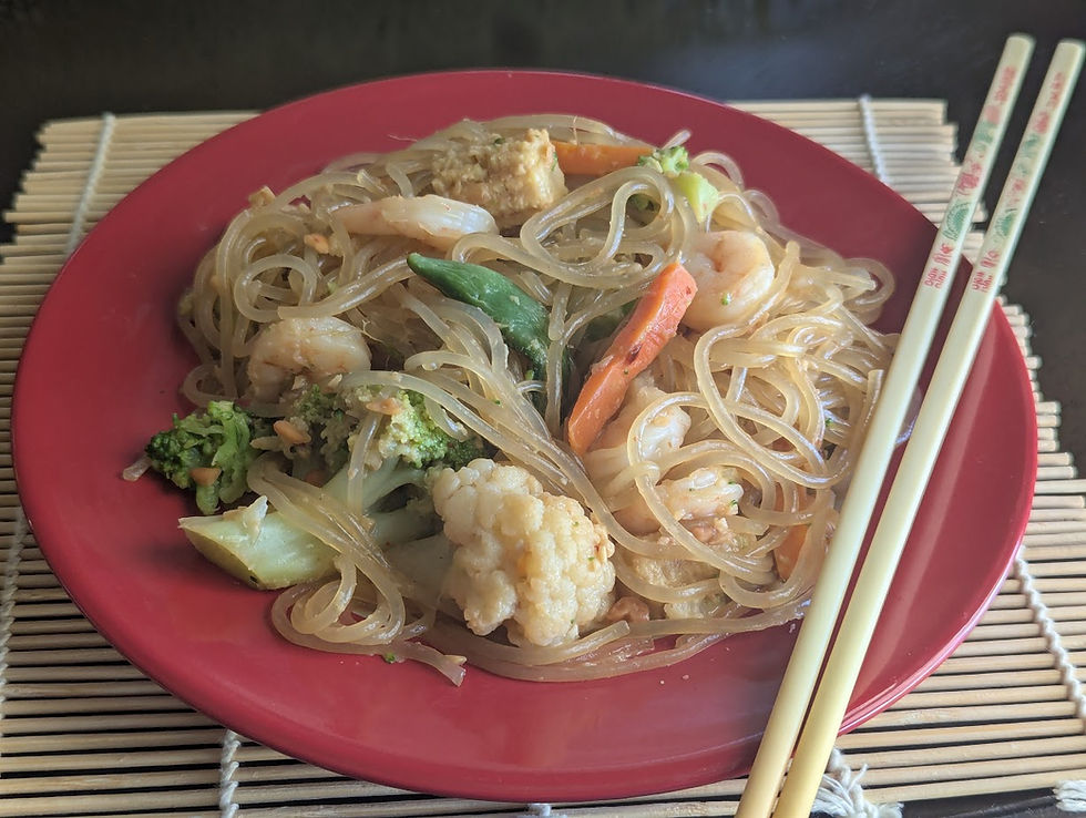 shrimp and vegetables in a peanut sauce on sweet potato noodles