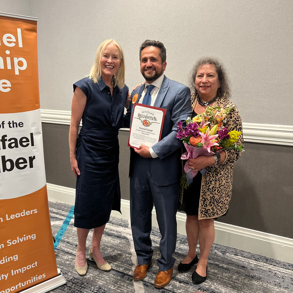 Man holding award with two women at San Rafael Chamber event