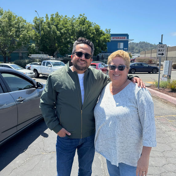 Man and woman smiling in an outdoor parking lot