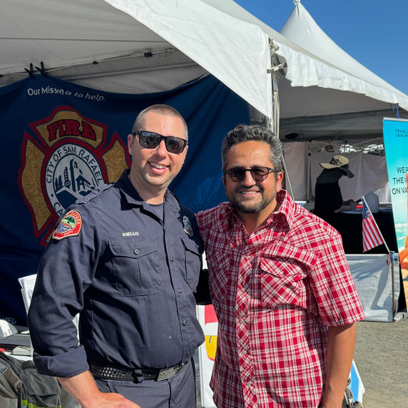 Firefighter in uniform and man in plaid shirt at an event