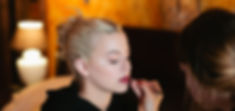 Asthildur makeup artist puts on lipstick.