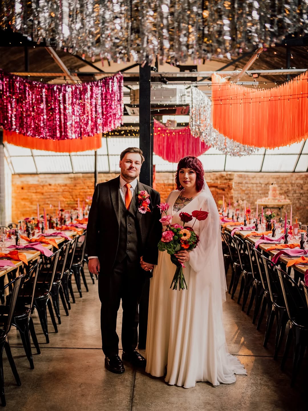 alternative wedding decor, alternative wedding stylists, pink and orange wedding styling, The Shack Revolution wedding venue, bold colourful wedding flowers, Streamadelica ceiling streamers, rockstar wedding welcome sign, burgundy and peach wedding colours, non-traditional wedding design, vibrant wedding photography UK