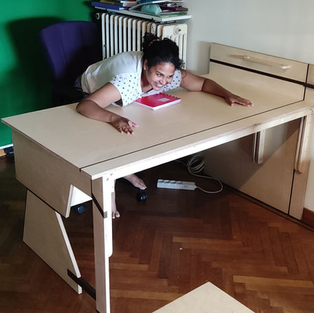 Woman sitting by desk made by art disguised as furniture