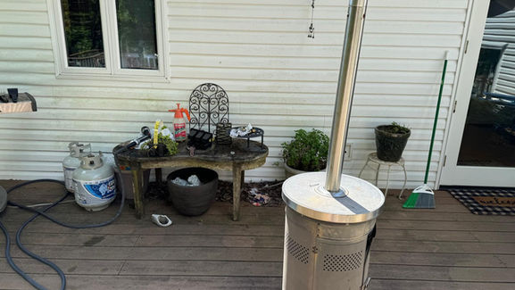 Dirty deck with unkempt outdoor furniture, showing dust and stains on the surfaces.