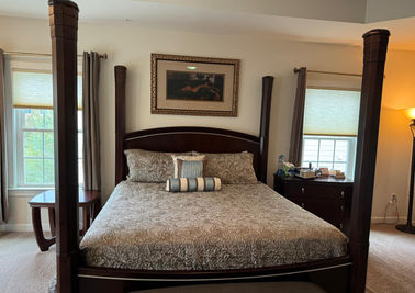 Neatly made bed with smooth sheets and arranged pillows in a tidy, serene bedroom.