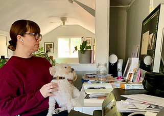 Student with their dog in an office setting watching Christina Vlinder's online Zoom class on their computer.