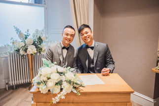 Dennis and Derek smiling at their Edinburgh wedding signing.