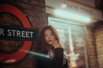 Woman posing by the Baker Street station sign in London.