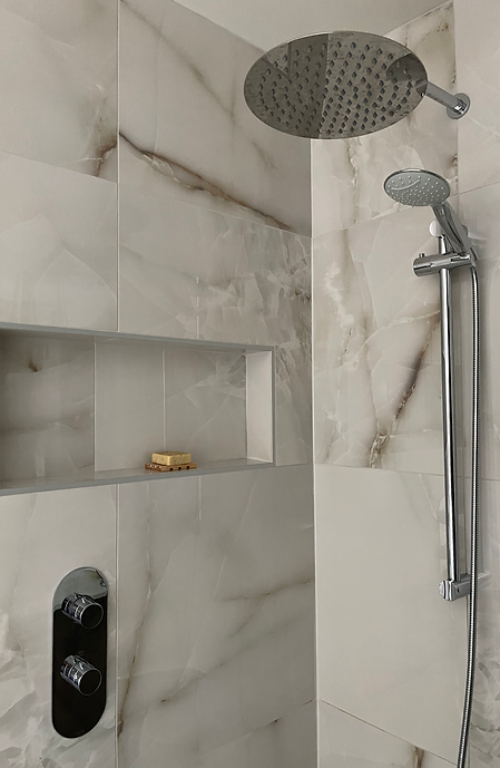 Détail du mur de douche en céramique grand format effet marbre.