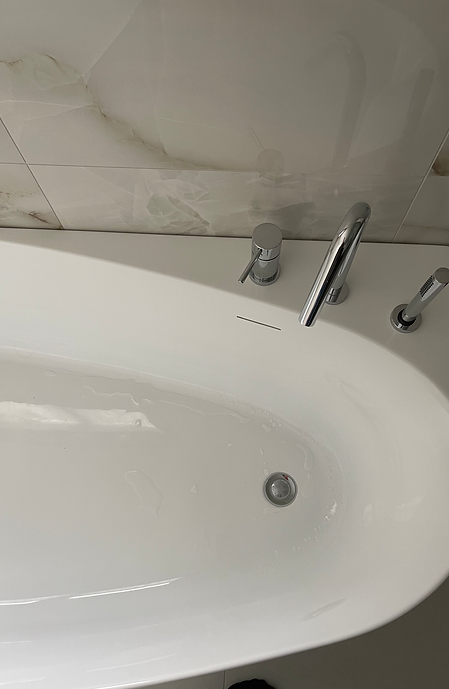Plafond épuré avec éclairage encastré au-dessus de la baignoire.
